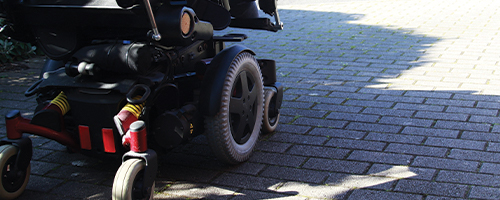 Photo featuring a power wheelchair outside.