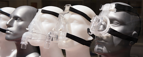 Photo featuring various CPAP masks on mannequin faces.